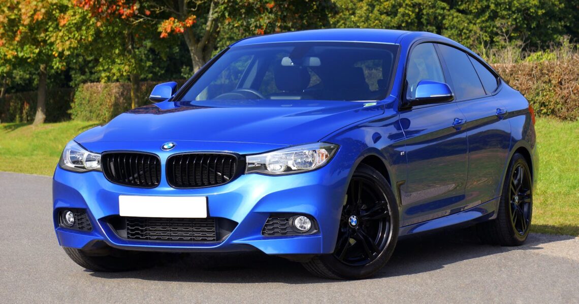 Modern blue luxury car parked by a scenic roadside on a sunny day. Stylish design.